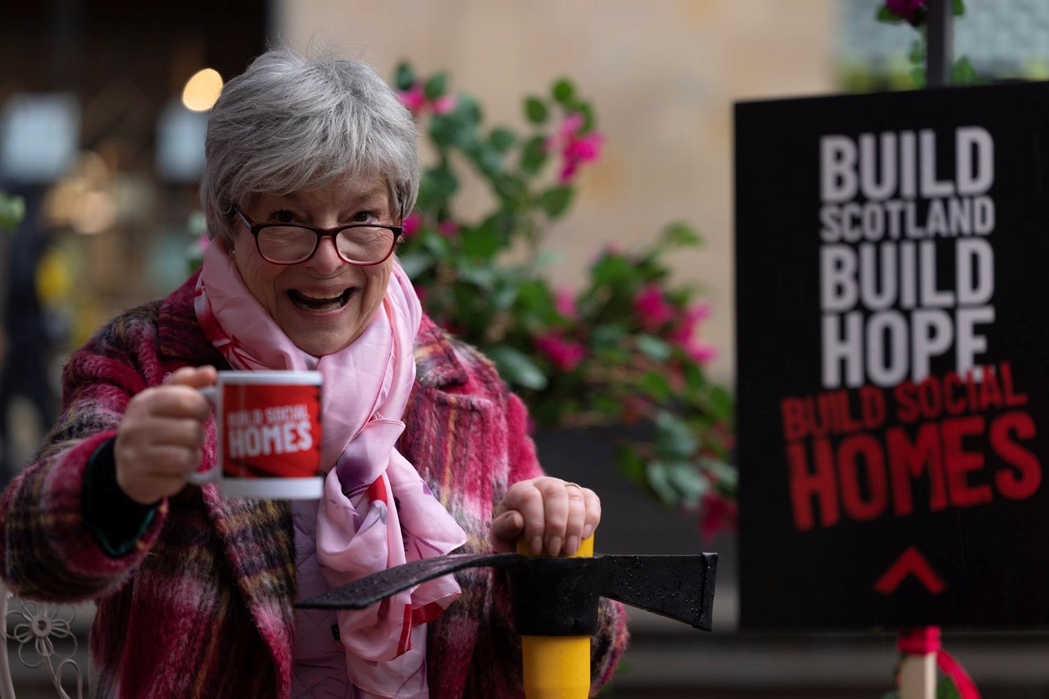 Gran holding a cup of tea and a pickaxe.